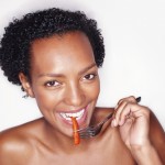 African American woman eating a salad from a bowl