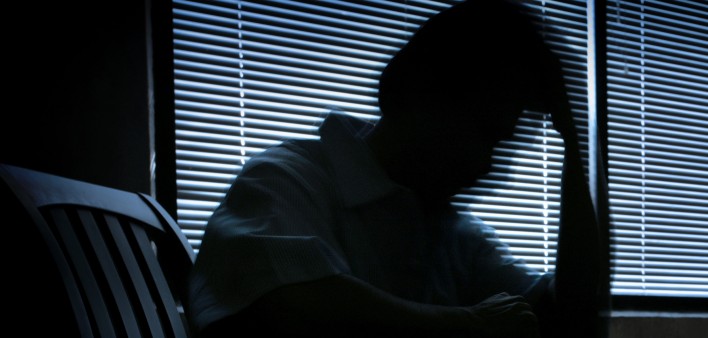 depressed man in a dark room 