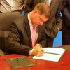 Boston Mayor Martin J. Walsh signs the Paris Declaration, surrounded by leaders of the HIV community.