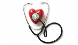 A stethoscope on a red plastic heart