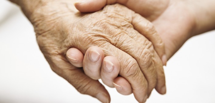 one hand holds the other elderly hand