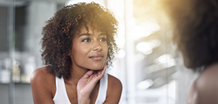 An African American woman looking in a mirror