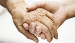 one hand holds the other elderly hand
