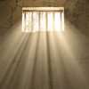 light shining through bars of prison window 