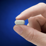 Genvoya pill held between two fingers