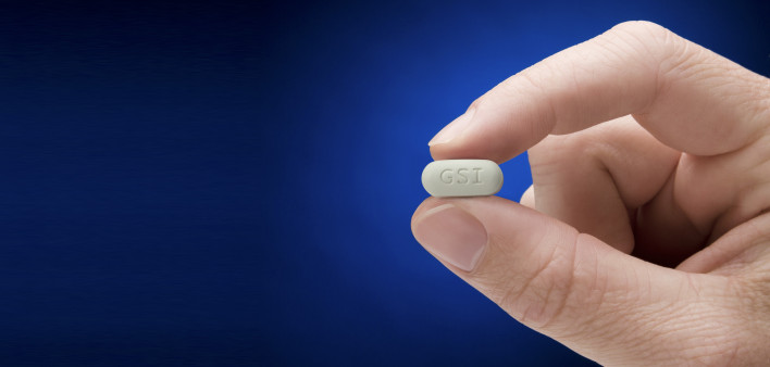 Genvoya pill held between two fingers