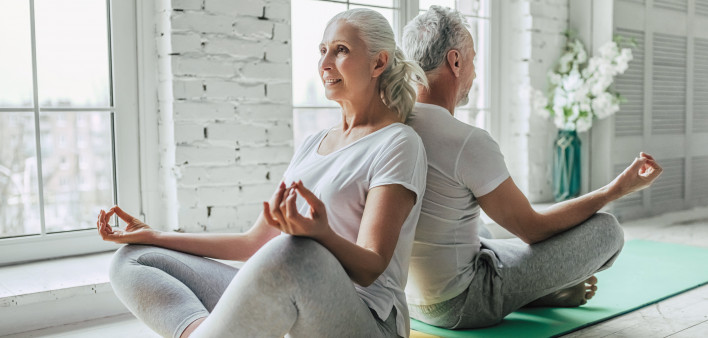 older man and woman doing yoga