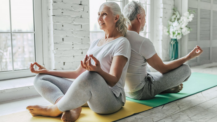 older man and woman doing yoga