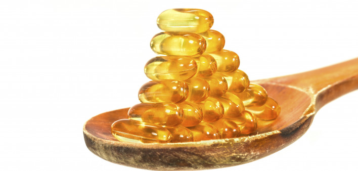 Vitamin D Capsules on wooden spoon