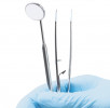gloved dentist hand holding dental tools