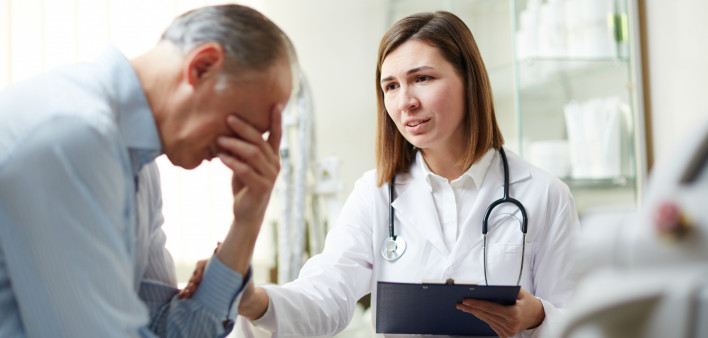 Young therapeutist comforting upset mature patient during appointment in hospital