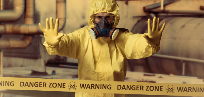 man in protective yellow gear and gas mask danger zone