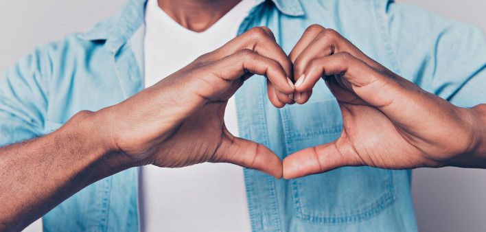 black man making shape of heart with his hands