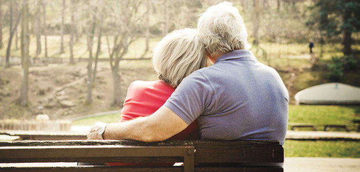 man and woman on park bench consoling