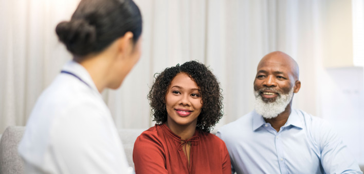 man and woman talking to a doctor