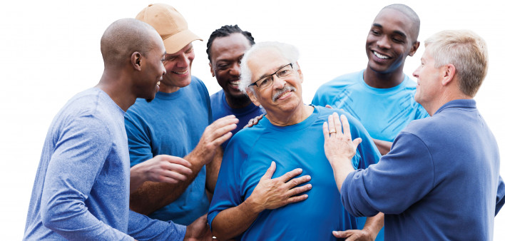 group of men supporting one man smiling