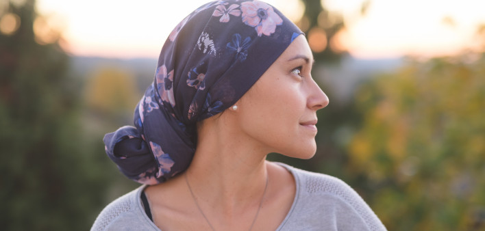 Ethnic woman battling cancer stands outside and contemplates her life