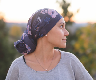 Ethnic woman battling cancer stands outside and contemplates her life