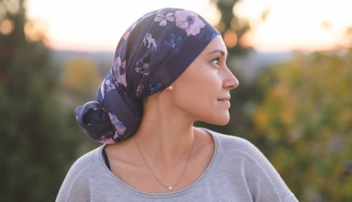 Ethnic woman battling cancer stands outside and contemplates her life