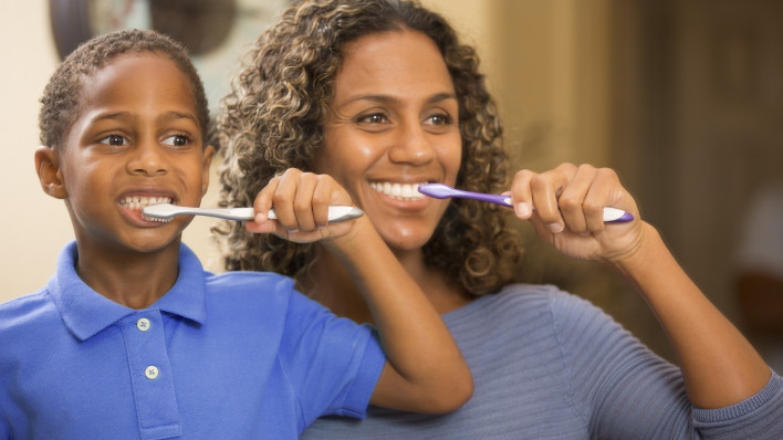 woman and boy brush teeth