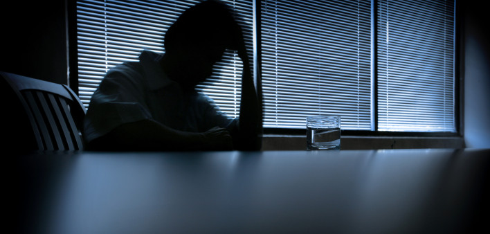 depressed man in a dark room 