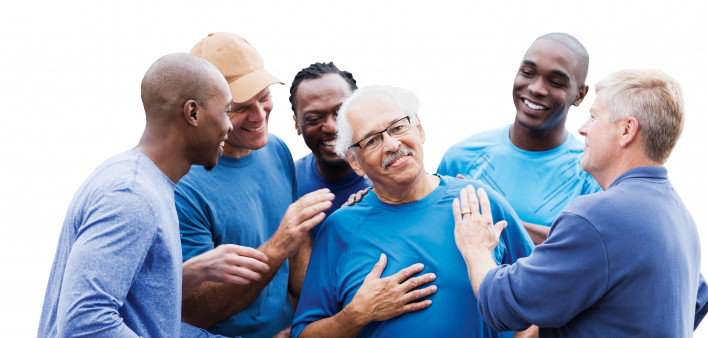 group of men supporting one man smiling