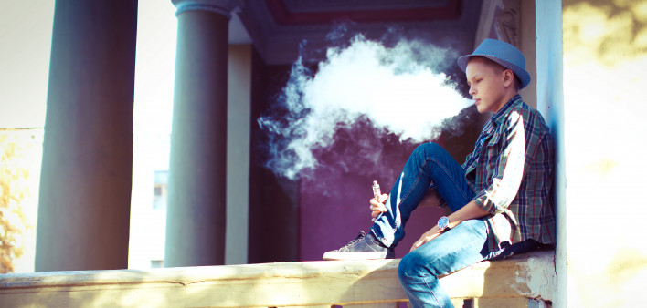 well dressed teen vaping e cigarette