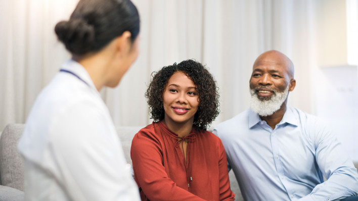man and woman talking to a doctor