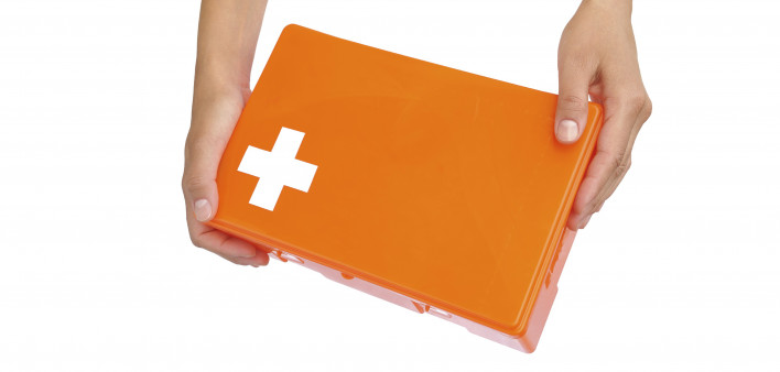 Hands of young woman holding first aid kit