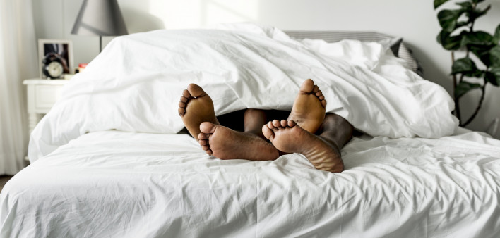african american black couple feet showing from under covers in bed