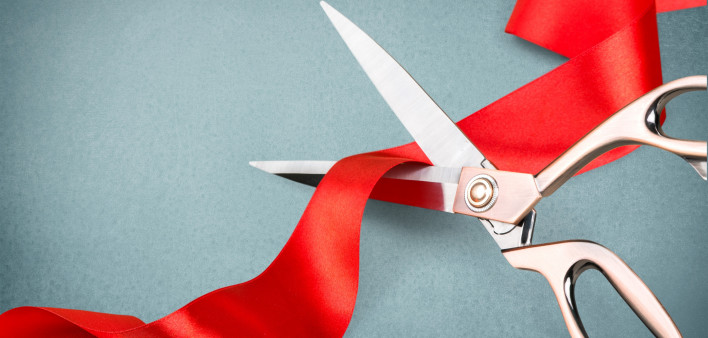 scissors cutting red ribbon