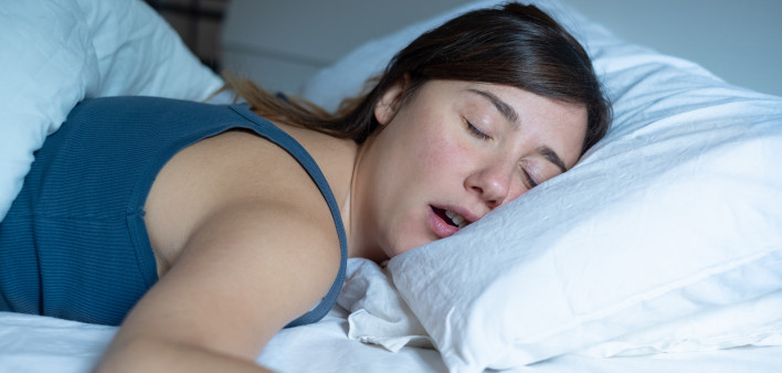 Face close up portrait of woman sleeping in bed and snoring