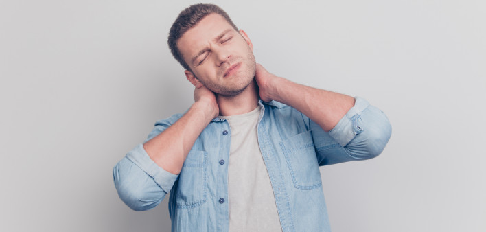 frowning feelings man close eyes hold two hands on neck feel pain stand isolated on light gray background
