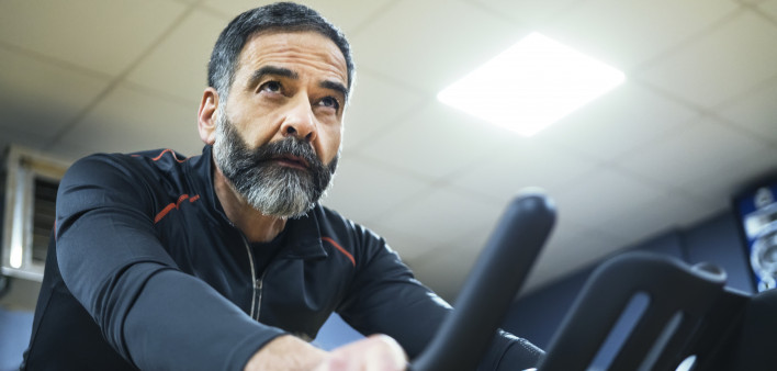 mature man exercise bike gym spin