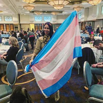 Maria Mejia waves the transgender flag at the conference