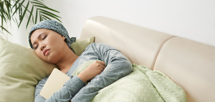 Asian woman with cancer sleeping on couch