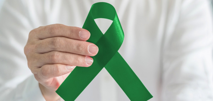 hand with green ribbon cerebral palsy and liver cancer awareness
