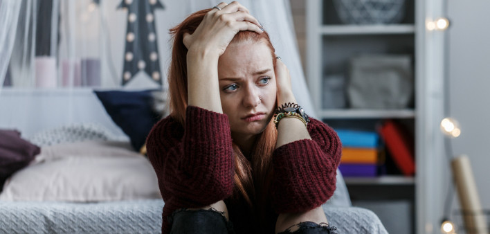 young woman depress holding head in bedroom