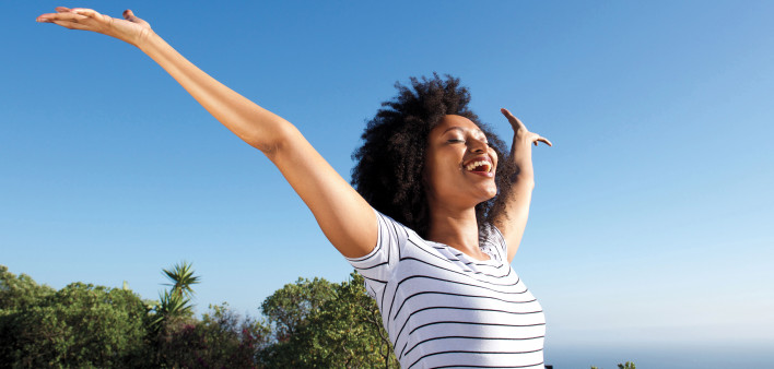 woman outside arms stretched happy