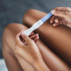 womans hands holding pregnancy test