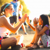 A counselor and a young camper play pattycake.
