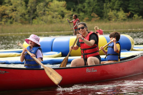 ATwo young campers and a counselor canoe.