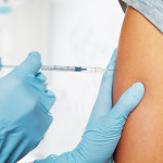 Nurse gives vaccination in the shoulder of patient in a clinic