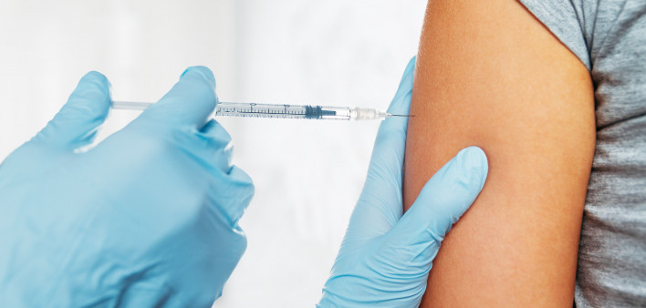 Nurse gives vaccination in the shoulder of patient in a clinic