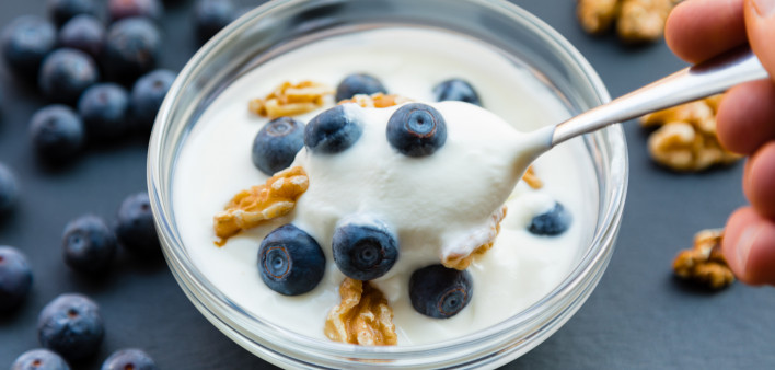 glass bowl yogurt blueberries and walnuts spoon