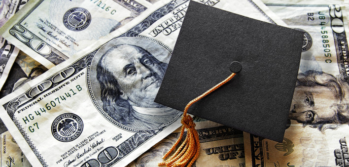 Graduation cap on cash 100 dollar bills