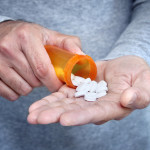 man taking pills pills in his hand