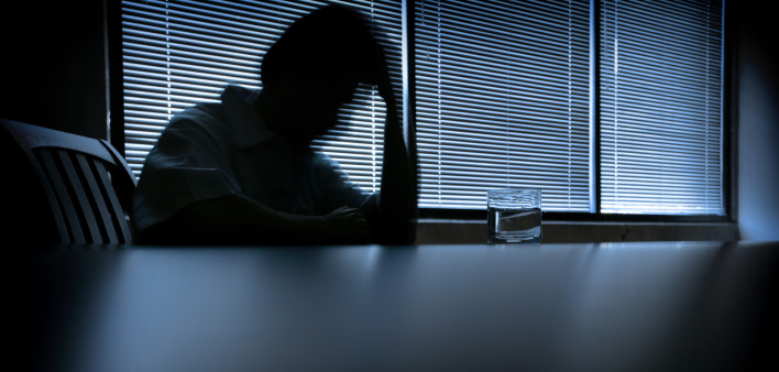 depressed man in a dark room 