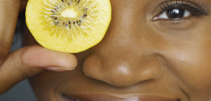 woman hold fruit up over eye