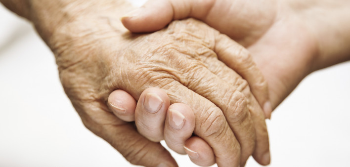one hand holds the other elderly hand